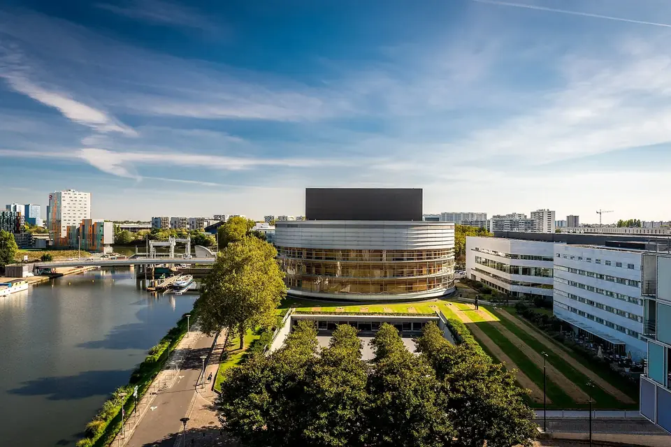 La Cité des congrès de Nantes, bâtiment arrondi au bord de l'eau, vue d'en haut avec les quartiers voisins
